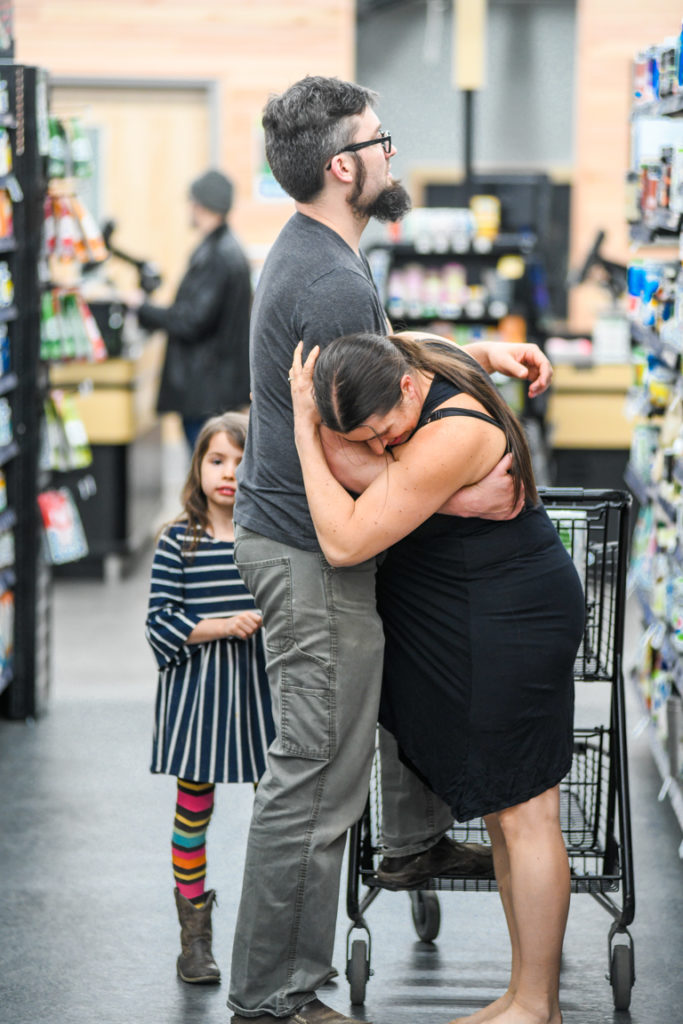 Woman in labor in co-op, while man looks at products.
